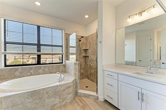 bathroom with a stall shower, a garden tub, and a healthy amount of sunlight