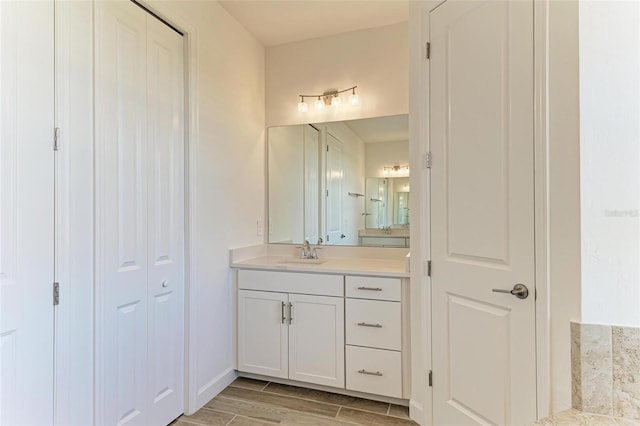 full bath with wood tiled floor, a closet, and vanity