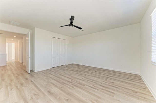 empty room with light wood-style floors, visible vents, ceiling fan, and baseboards