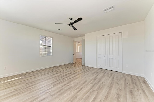 unfurnished bedroom with light wood finished floors, a closet, visible vents, and baseboards