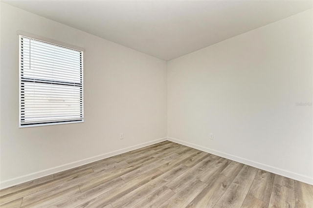 spare room featuring light wood-style flooring and baseboards