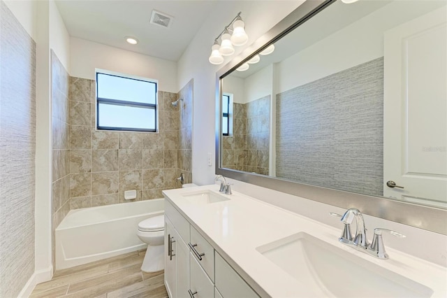 full bathroom featuring toilet, wood finished floors, a sink, and visible vents