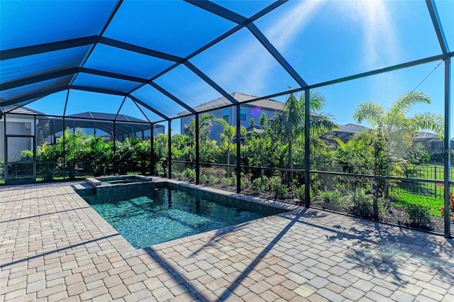 view of pool with a pool with connected hot tub, glass enclosure, and a patio