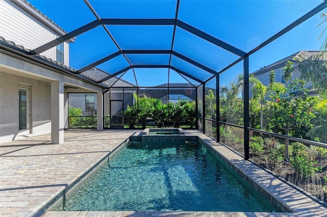 view of pool featuring glass enclosure, a patio, and a pool with connected hot tub