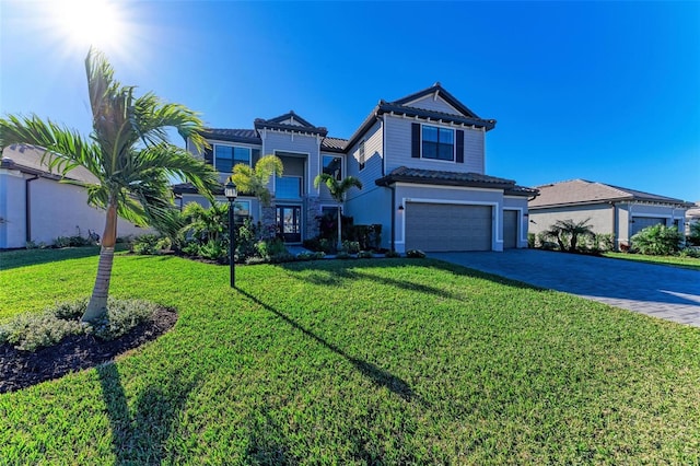 view of front of house featuring an attached garage, a front lawn, and decorative driveway