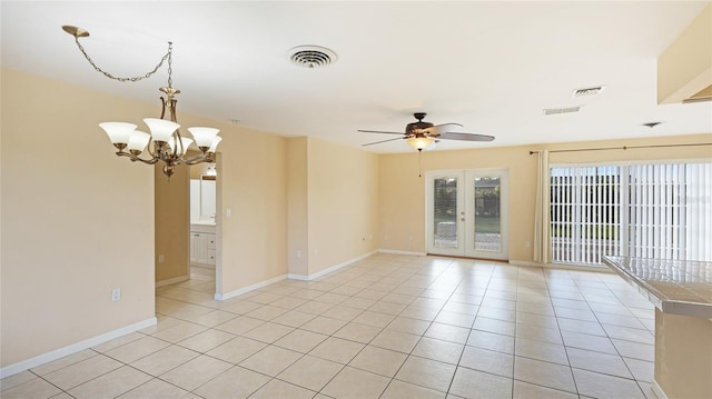 spare room with french doors, ceiling fan with notable chandelier, and light tile patterned floors