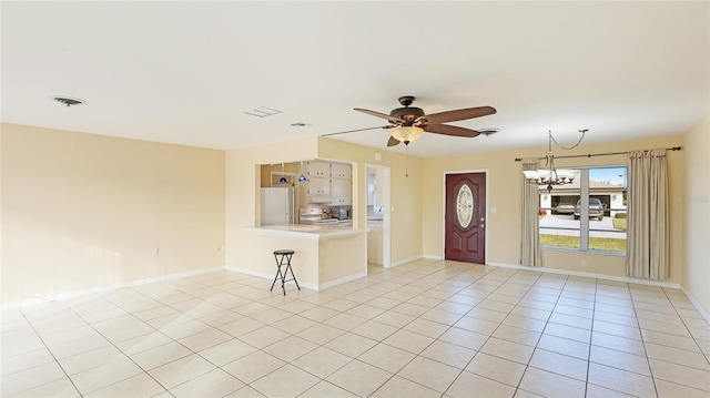 tiled foyer featuring ceiling fan with notable chandelier