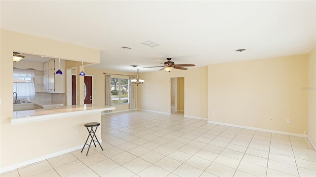 unfurnished room with sink, light tile patterned floors, and ceiling fan