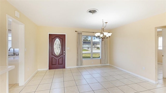 foyer entrance with an inviting chandelier and light tile patterned floors