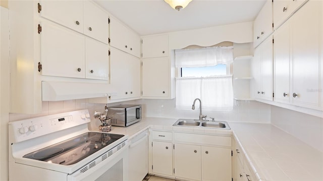 kitchen with white cabinetry, sink, white appliances, and tile countertops