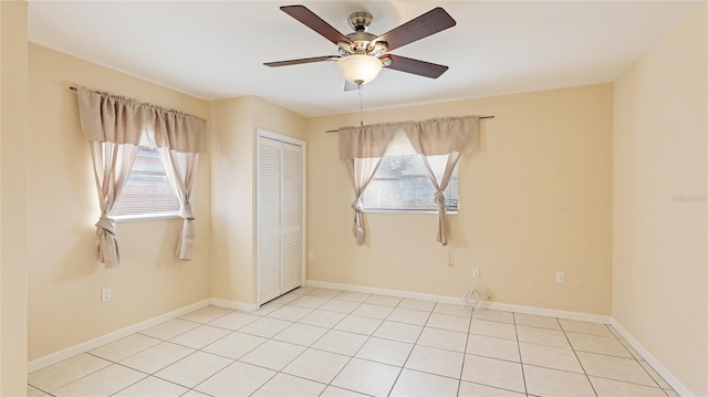 tiled spare room with ceiling fan