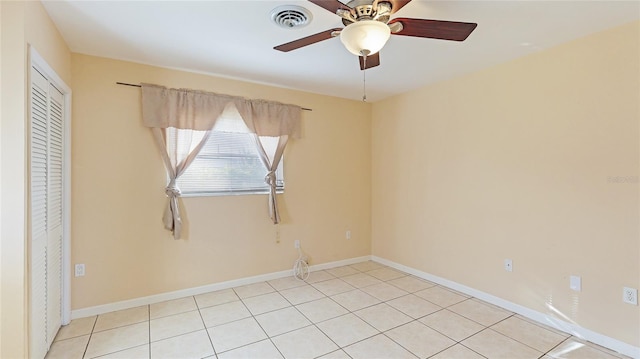 empty room featuring ceiling fan and light tile patterned floors