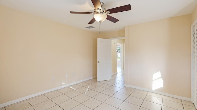 tiled empty room featuring ceiling fan