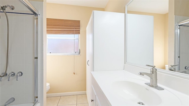 bathroom with vanity, a shower with shower door, tile patterned floors, and toilet