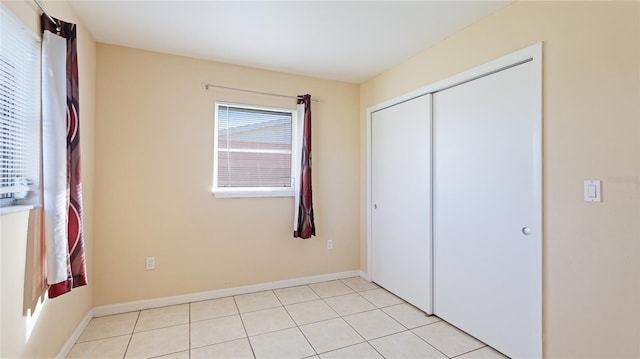 unfurnished bedroom with a closet and light tile patterned flooring