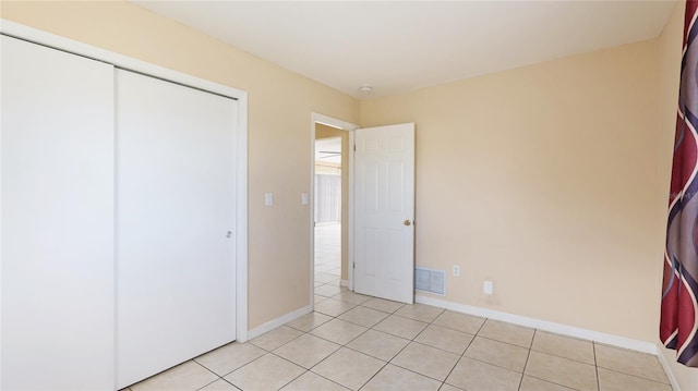 unfurnished bedroom featuring a closet and light tile patterned flooring