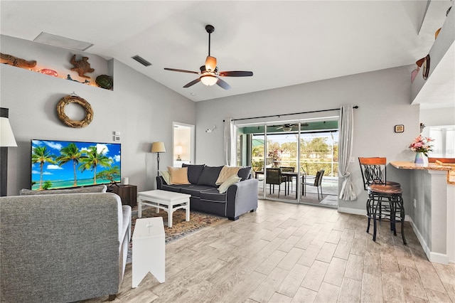 living room with ceiling fan, lofted ceiling, and light wood-type flooring