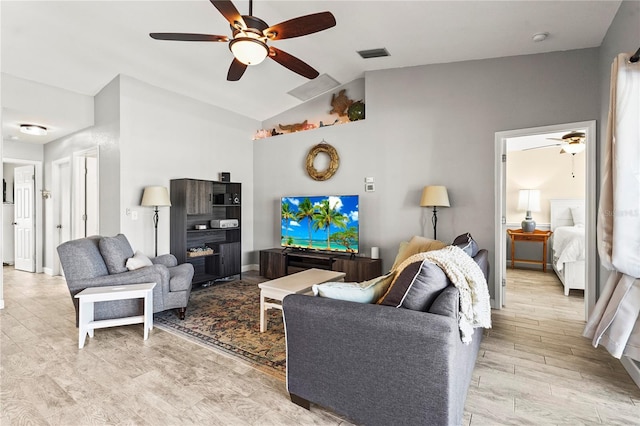 living room featuring ceiling fan, lofted ceiling, and light hardwood / wood-style floors