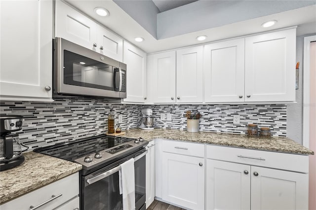 kitchen with white cabinetry, tasteful backsplash, light stone countertops, and appliances with stainless steel finishes