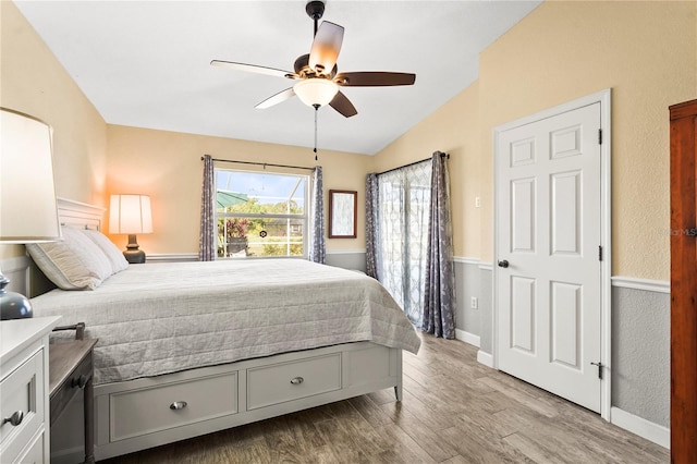 bedroom with lofted ceiling, light hardwood / wood-style flooring, and ceiling fan