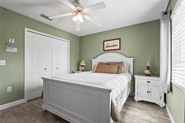 bedroom with ceiling fan, dark hardwood / wood-style flooring, and a closet