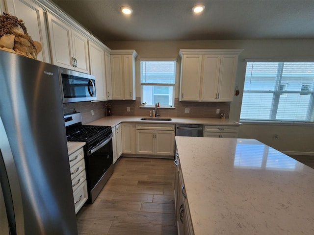 kitchen with white cabinetry, sink, hardwood / wood-style flooring, and stainless steel appliances