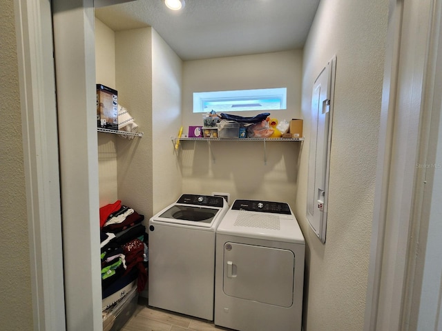 washroom with light hardwood / wood-style floors and independent washer and dryer