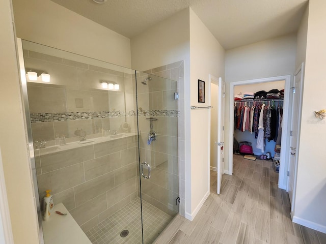 bathroom with hardwood / wood-style floors, a textured ceiling, and walk in shower