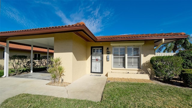 property entrance featuring a carport and a yard