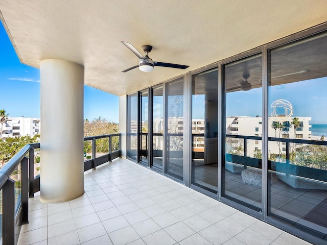 balcony featuring a water view and ceiling fan