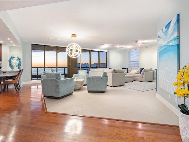 living room with hardwood / wood-style floors, a notable chandelier, and expansive windows