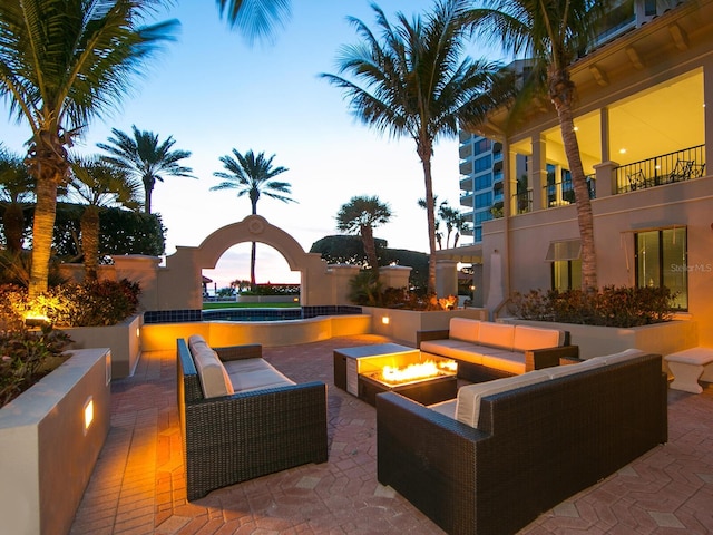 patio terrace at dusk featuring an outdoor living space with a fire pit