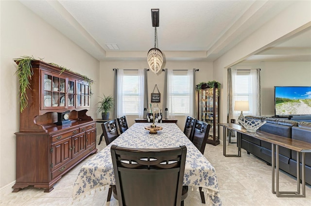 dining room with a raised ceiling