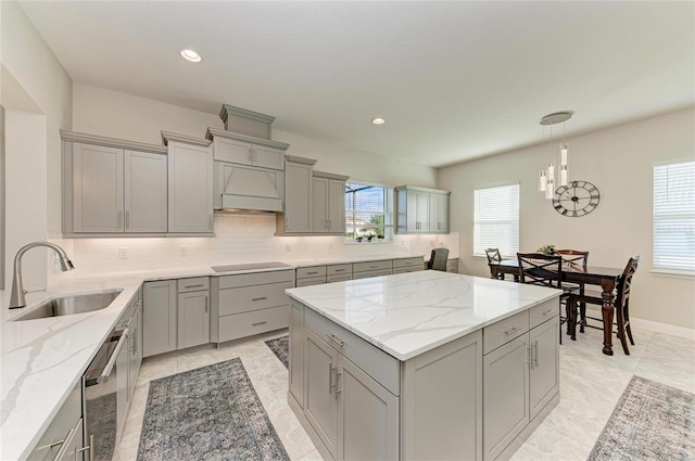 kitchen with sink, premium range hood, gray cabinetry, hanging light fixtures, and black electric stovetop