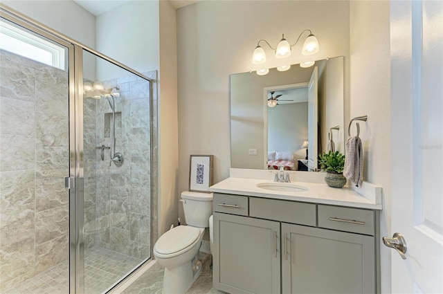 bathroom featuring a shower with door, vanity, and toilet