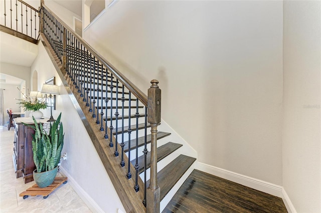 stairs with a high ceiling and wood-type flooring