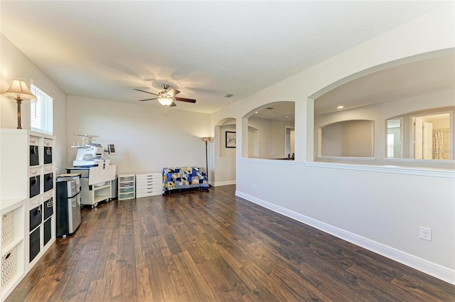 living room featuring dark hardwood / wood-style floors, a textured ceiling, and ceiling fan