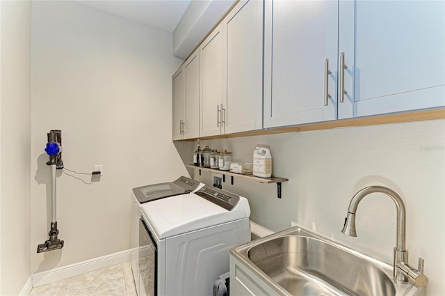 washroom with cabinets, sink, and washer and dryer