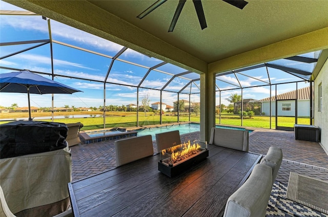 view of patio / terrace with a lanai, a grill, ceiling fan, and a fire pit