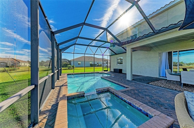 view of pool featuring an in ground hot tub, a lanai, and a lawn