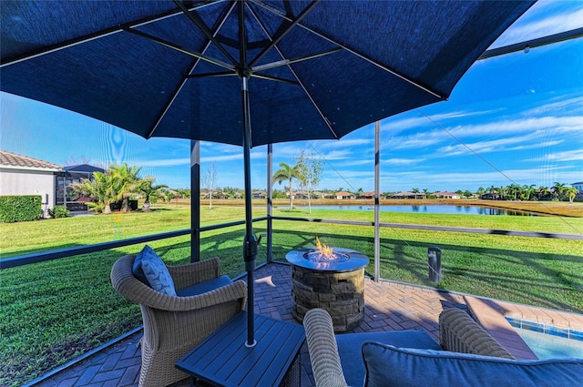 view of patio / terrace featuring an outdoor fire pit and a water view