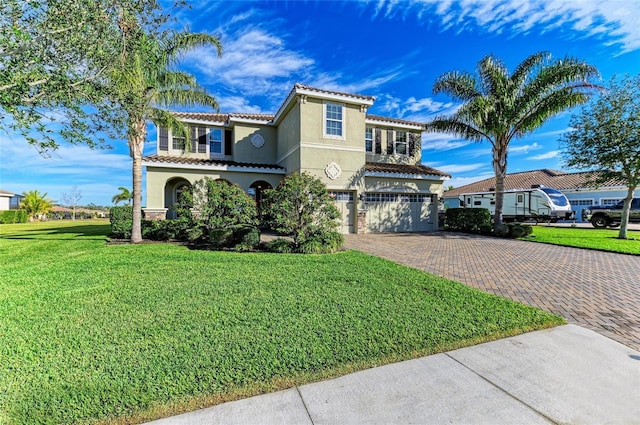 mediterranean / spanish-style home featuring a garage and a front lawn