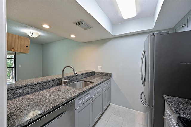 kitchen featuring dark stone countertops, sink, and stainless steel appliances