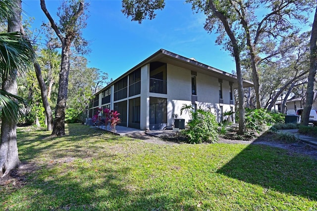 view of property exterior featuring a sunroom and a lawn