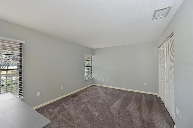 unfurnished bedroom with carpet floors, a closet, and a textured ceiling