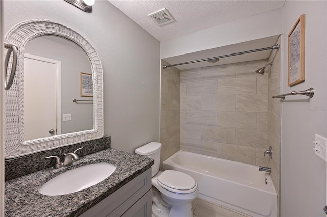 full bathroom featuring tile patterned floors, toilet, tiled shower / bath, a textured ceiling, and vanity