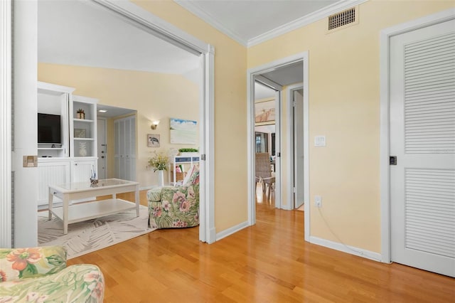 interior space with crown molding, lofted ceiling, and hardwood / wood-style floors