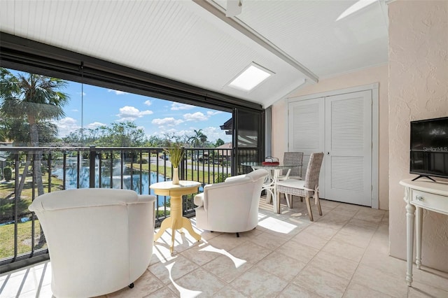 sunroom / solarium with a water view and lofted ceiling with beams