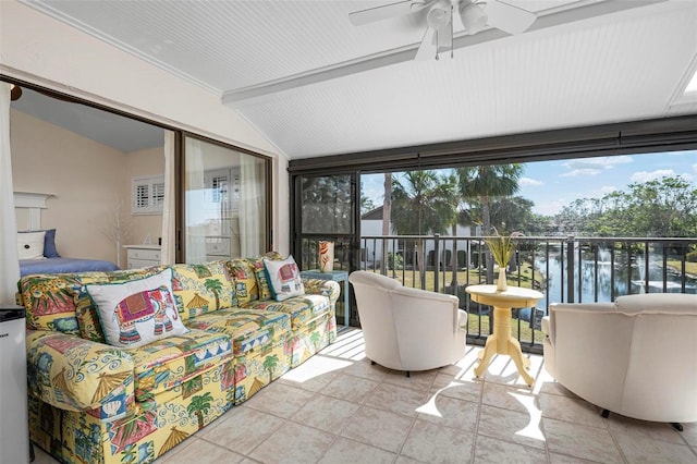 sunroom with a water view, lofted ceiling, and ceiling fan