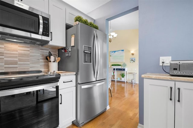 kitchen featuring appliances with stainless steel finishes, light hardwood / wood-style flooring, decorative backsplash, and white cabinets